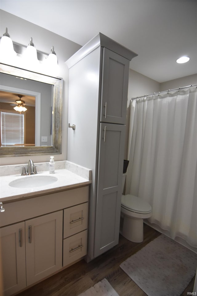 bathroom featuring a shower with curtain, recessed lighting, vanity, toilet, and wood finished floors