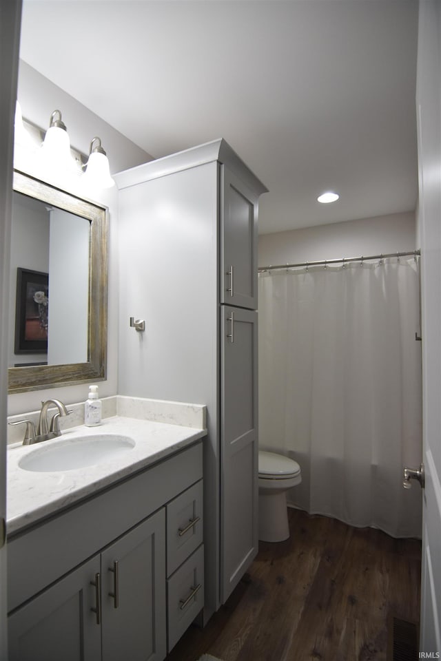 bathroom with recessed lighting, vanity, toilet, wood finished floors, and a shower with shower curtain