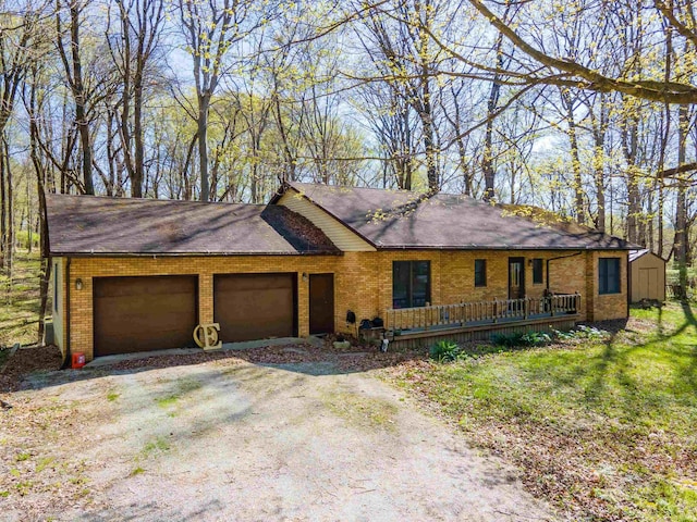 view of front of property with dirt driveway, an attached garage, a shingled roof, and brick siding