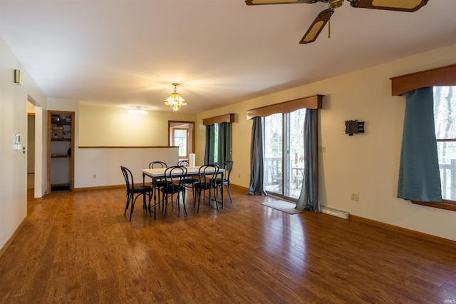 dining area featuring wood finished floors, baseboards, and ceiling fan with notable chandelier