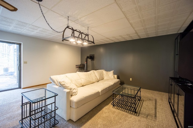 carpeted living room featuring a paneled ceiling and baseboards