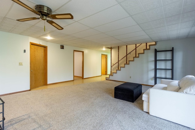 living area featuring stairs, ceiling fan, carpet, and baseboards