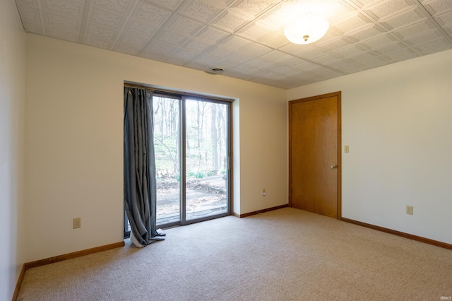 unfurnished room with baseboards and light colored carpet