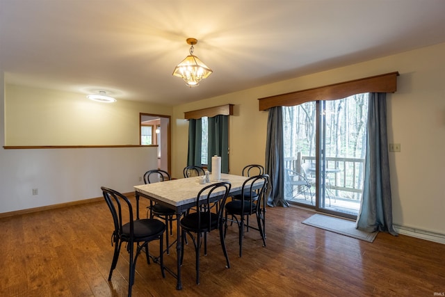 dining space with wood finished floors, a chandelier, and baseboards