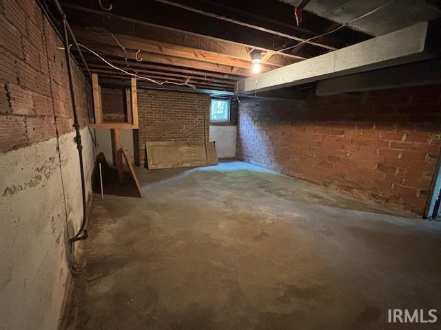 basement featuring brick wall