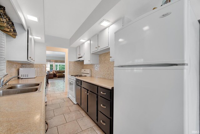 302 N Main St, Culver, IN 46511 - kitchen with white appliances, a sink, light countertops, decorative backsplash, and white cabinetry