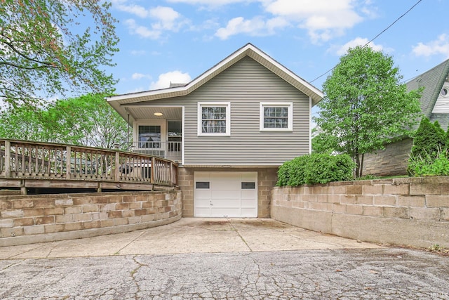 302 N Main St, Culver, IN 46511 - back of house with driveway, a garage, and a wooden deck