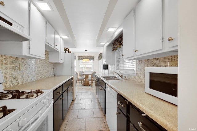 302 N Main St, Culver, IN 46511 - kitchen with white appliances, under cabinet range hood, white cabinetry, and a sink