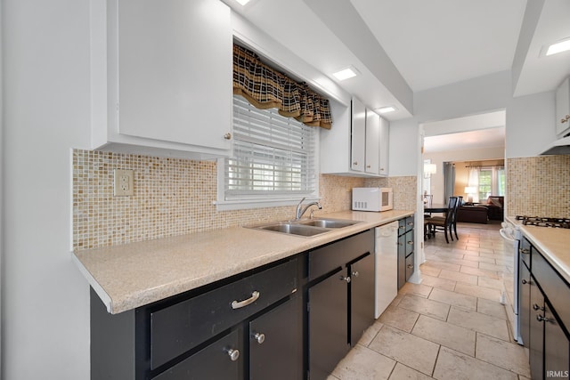 302 N Main St, Culver, IN 46511 - kitchen featuring white appliances, a sink, tasteful backsplash, light countertops, and white cabinetry