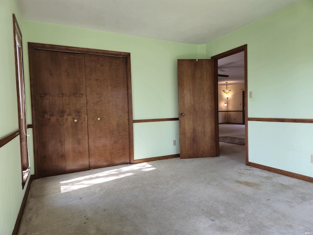 unfurnished bedroom with baseboards, a closet, and carpet