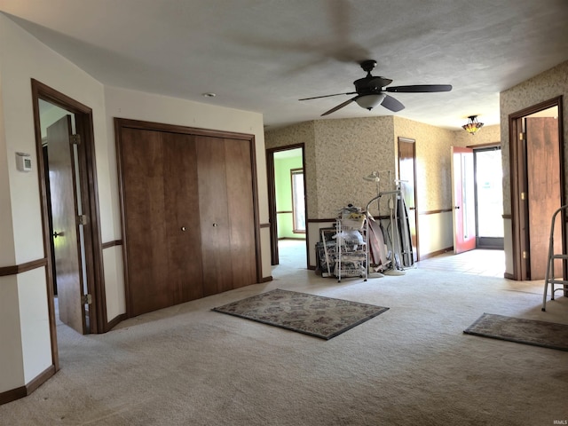 foyer entrance with ceiling fan, baseboards, carpet, and a healthy amount of sunlight