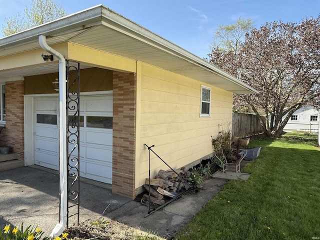 540 Fairfield Dr, Wabash, IN 46992 - view of side of home with a lawn, fence, a garage, and brick siding