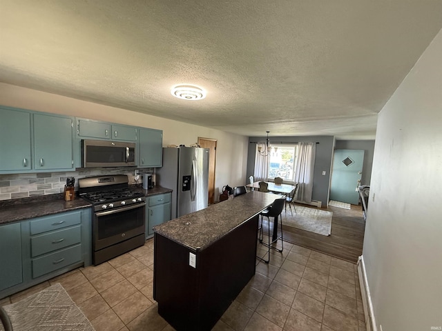 540 Fairfield Dr, Wabash, IN 46992 - kitchen featuring appliances with stainless steel finishes, a breakfast bar, baseboards, dark tile patterned floors, and backsplash