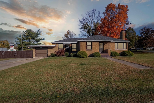 ranch-style home featuring brick siding, fence, a front yard, concrete driveway, and an attached garage