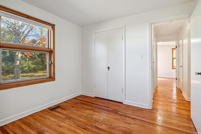 unfurnished bedroom with visible vents, baseboards, and light wood-style floors