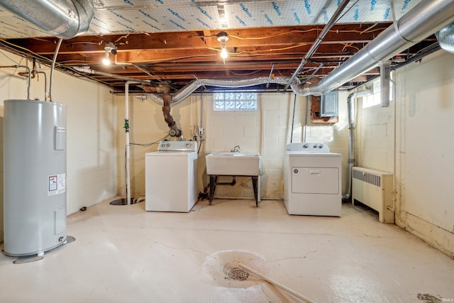 basement with radiator, a sink, washer and clothes dryer, and electric water heater