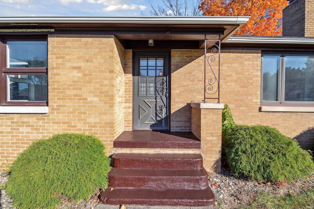 doorway to property featuring brick siding