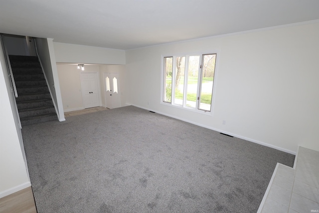 unfurnished living room with stairway, carpet, and baseboards