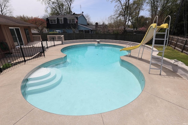 view of swimming pool with a fenced in pool, a fenced backyard, a water slide, and a patio area