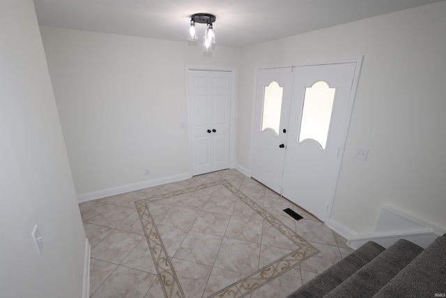 tiled foyer entrance featuring stairs and baseboards