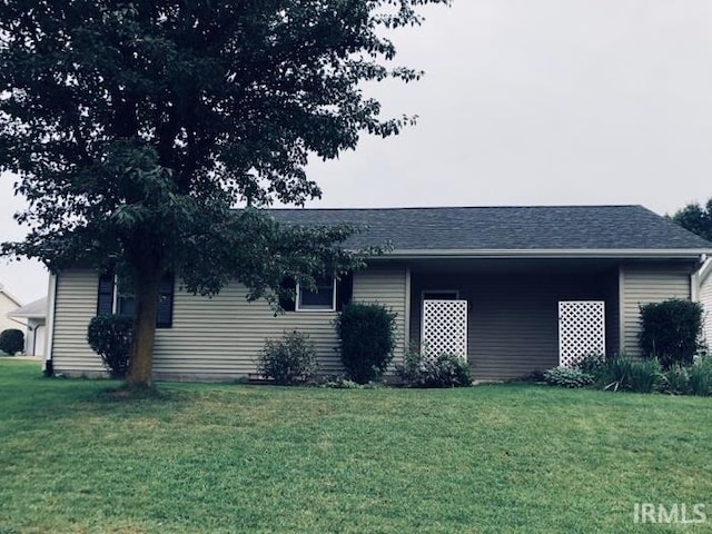 exterior space featuring roof with shingles and a front yard