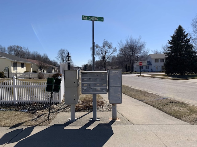 exterior details with fence, a residential view, and mail area