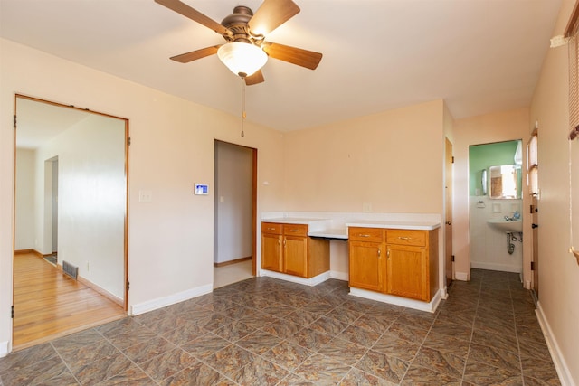 315 E Dean St, South Bend, IN 46614 - kitchen featuring brown cabinets, light countertops, ceiling fan, and baseboards