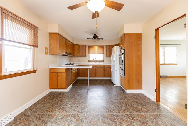 315 E Dean St, South Bend, IN 46614 - kitchen featuring a sink, a warming drawer, stainless steel oven, brown cabinets, and light countertops