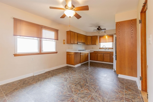 315 E Dean St, South Bend, IN 46614 - kitchen with brown cabinetry, baseboards, light countertops, and ceiling fan