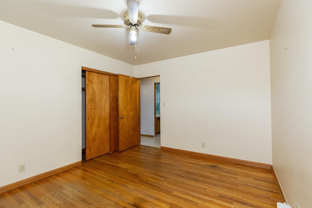 315 E Dean St, South Bend, IN 46614 - unfurnished bedroom featuring wood finished floors, baseboards, a closet, and a ceiling fan