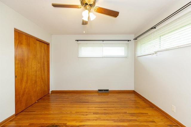 315 E Dean St, South Bend, IN 46614 - unfurnished bedroom with a closet, light wood-style flooring, ceiling fan, and baseboards