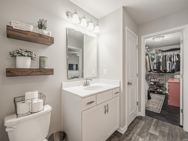 bathroom with wood finished floors, toilet, and vanity
