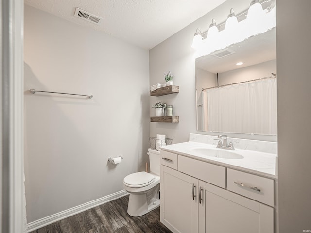 bathroom with wood finished floors, visible vents, toilet, and baseboards