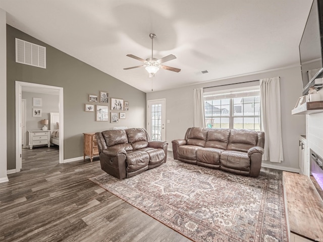 living area featuring lofted ceiling, visible vents, a ceiling fan, and dark wood finished floors
