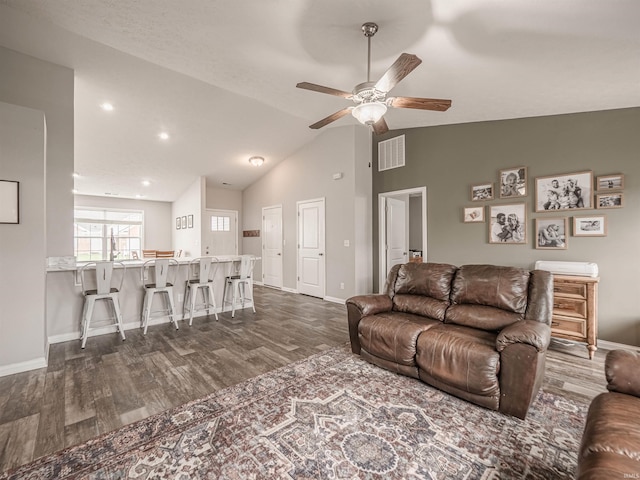 living area with vaulted ceiling, ceiling fan, dark wood-style flooring, baseboards, and visible vents