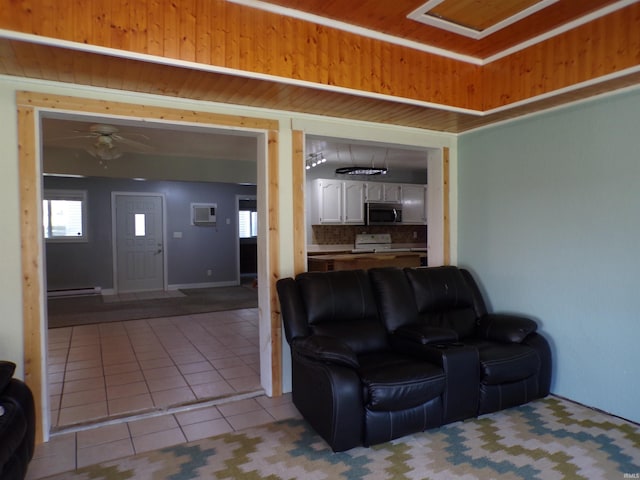 living room featuring light tile patterned floors, a healthy amount of sunlight, and baseboard heating