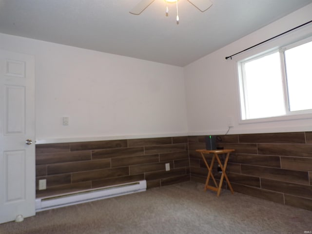 carpeted empty room with lofted ceiling, a ceiling fan, and baseboard heating
