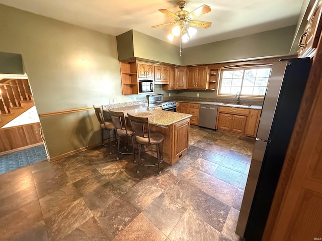 kitchen featuring a peninsula, open shelves, appliances with stainless steel finishes, and brown cabinetry