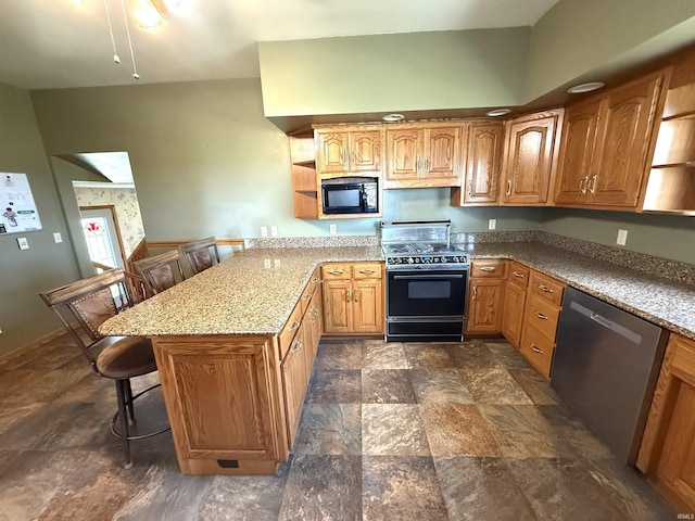 kitchen with stone finish floor, a breakfast bar area, open shelves, black appliances, and a peninsula