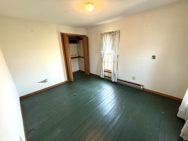 unfurnished bedroom featuring a baseboard heating unit, baseboards, dark wood finished floors, and a closet