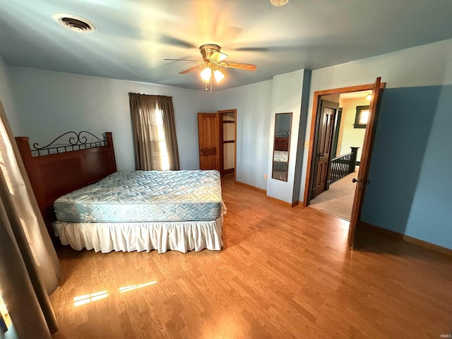 bedroom featuring baseboards, a ceiling fan, light wood-type flooring, and visible vents