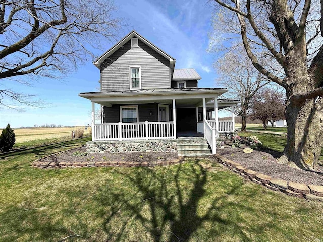 view of front of house featuring covered porch, a standing seam roof, metal roof, and a front yard