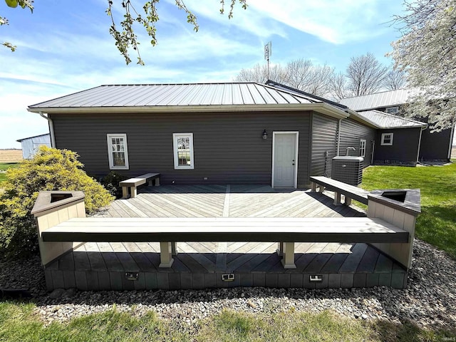 back of house with central AC, metal roof, and a wooden deck