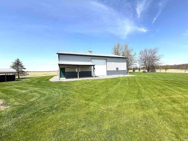 back of property featuring a garage, an outbuilding, and a yard