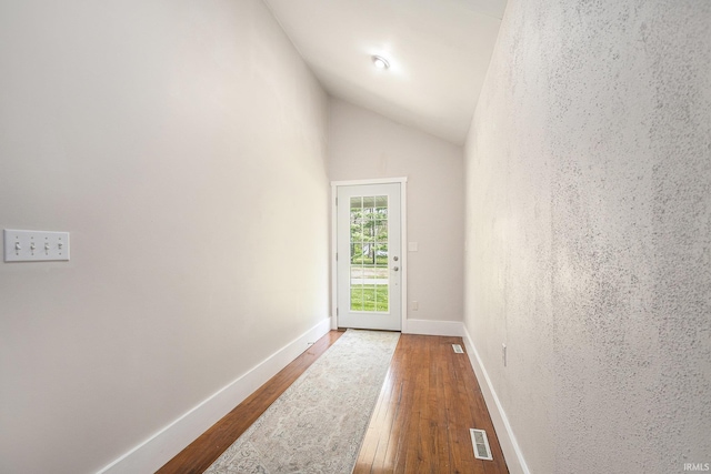 entryway with baseboards, visible vents, lofted ceiling, and hardwood / wood-style flooring