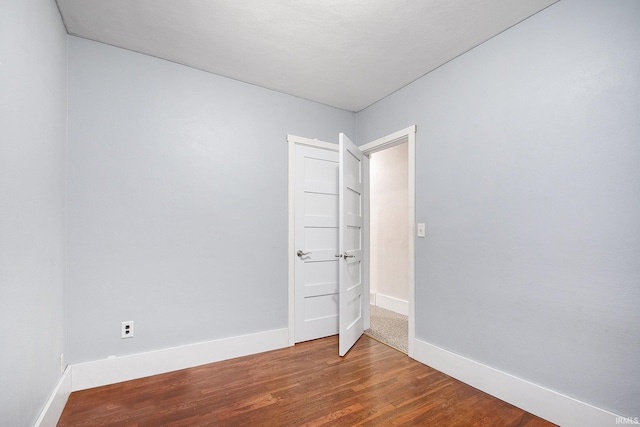 unfurnished room featuring baseboards and wood finished floors
