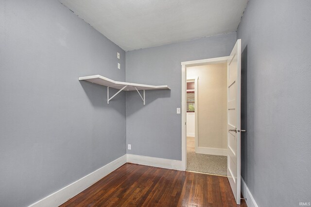 walk in closet with wood finished floors