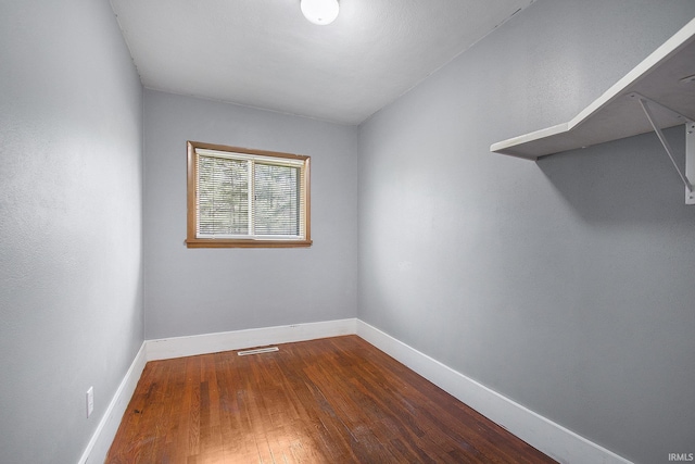empty room with baseboards and wood finished floors