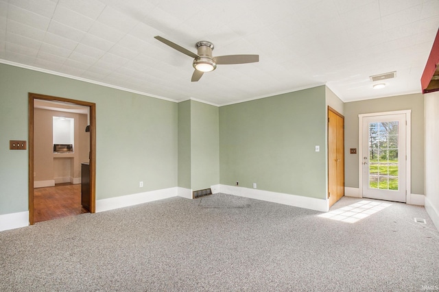 unfurnished room featuring ceiling fan, visible vents, crown molding, carpet floors, and baseboards