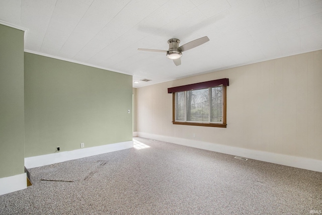 carpeted spare room with baseboards, a ceiling fan, and visible vents